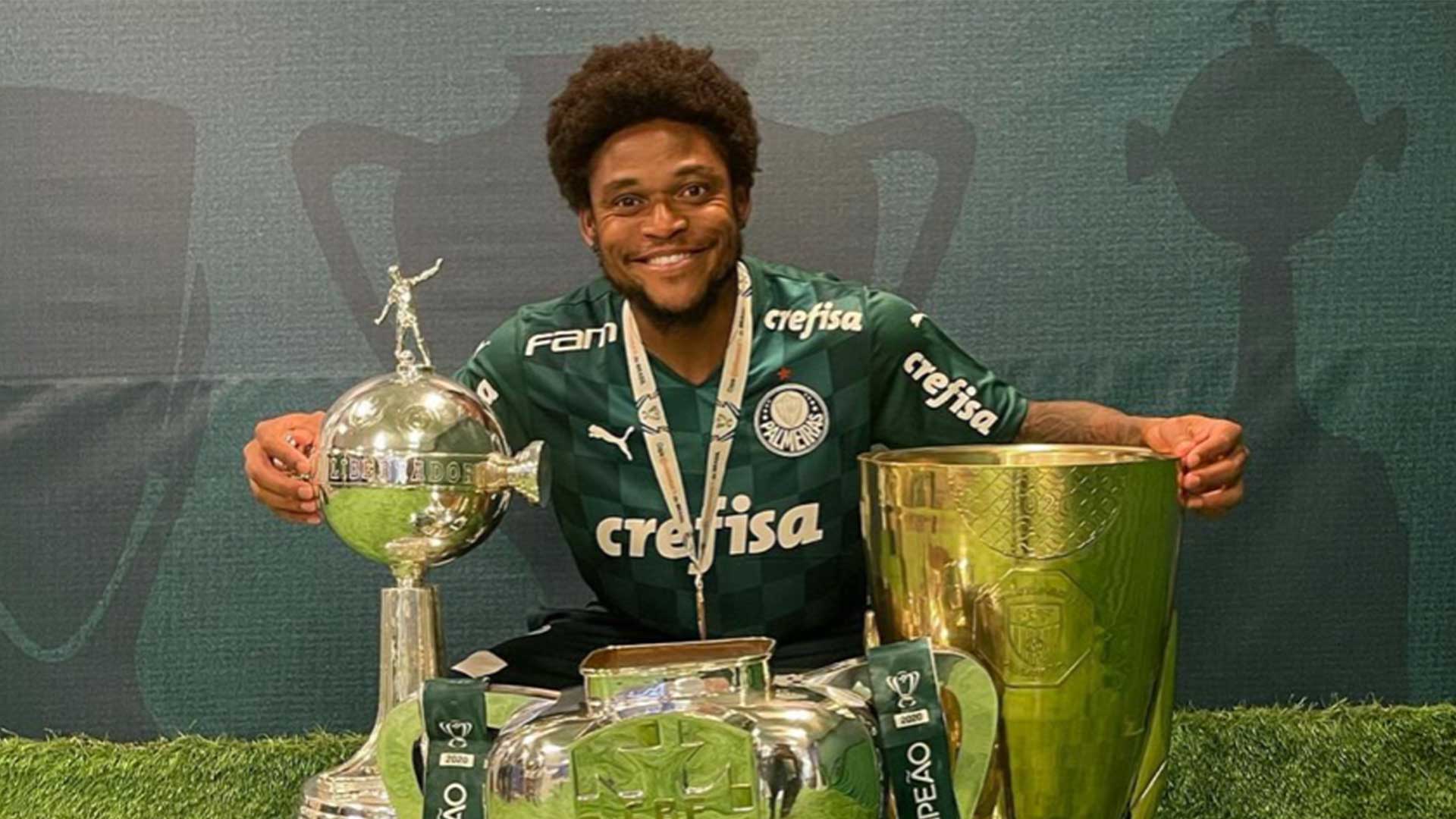 Luiz Adriano poses with several trophies and a medal