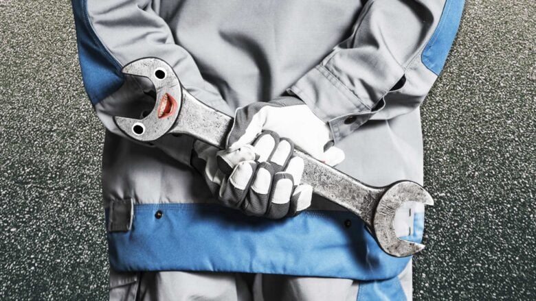 A motorcycle mechanic holding a spanner