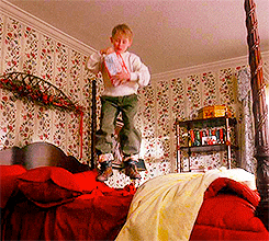 Home Alone's Kevin jumps on a big bed